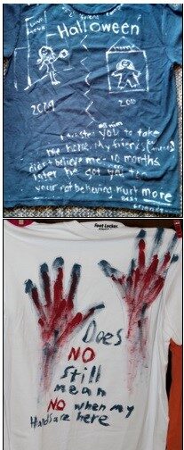 Two shirts, one blue and one white. One has drawings in white, the other, handprints in red.